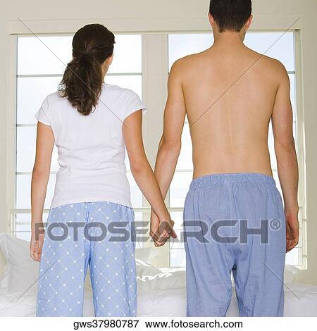 Stock Photo - Rear view of a young couple holding hands. Fotosearch