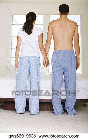 Rear view of a young couple holding hands View Large Photo Image Stock Photography - Rear view of a young couple holding hands. Fotosearch