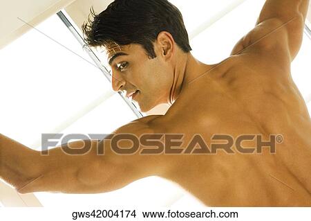 Rear view of a young man smiling View Large Photo Image Picture - Rear view of a young man smiling. Fotosearch