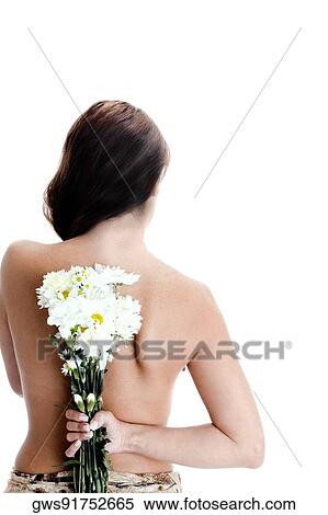 Rear view of a young woman hiding a bunch of flowers behind her back View Large Photo Image Stock Photography - Rear view of a young woman hiding a bunch of flowers behind her back. Fotosearch