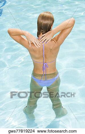 Rear view of a young woman in a swimming pool View Large Photo Image Picture - Rear view of a young woman in a swimming pool. Fotosearch