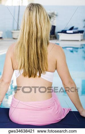 Rear view of a young woman sitting at the poolside View Large Photo Image Stock Image - Rear view of a young woman sitting at the poolside. Fotosearch