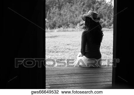 Rear view of a young woman sitting on the porch View Large Photo Image Stock Image - Rear view of a young woman sitting on the porch. Fotosearch