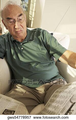 Senior man reading a newspaper View Large Photo Image Stock Photo - Senior man reading a newspaper. Fotosearch
