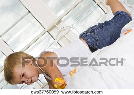 Side profile of a boy lying on the bed View Large Photo Image Stock Photo - Side profile of a boy lying on the bed. Fotosearch