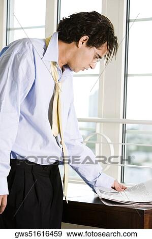 Side profile of a businessman reading a newspaper View Large Photo Image Stock Photo - Side profile of a businessman reading a newspaper. Fotosearch