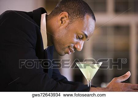 Side profile of a businessman with a glass of martini View Large Photo Image Picture - Side profile of a businessman with a glass of martini. Fotosearch