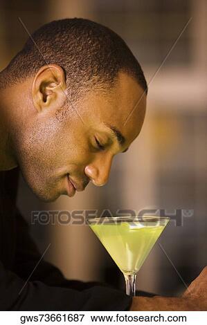 Side profile of a businessman with a glass of martini View Large Photo Image Stock Photo - Side profile of a businessman with a glass of martini. Fotosearch