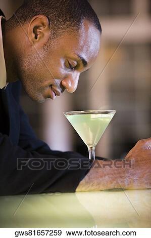 Side profile of a businessman with a glass of martini View Large Photo Image Stock Photo - Side profile of a businessman with a glass of martini. Fotosearch