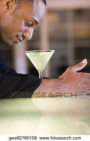 Side profile of a businessman with a glass of martini View Large Photo Image Stock Photo - Side profile of a businessman with a glass of martini. Fotosearch