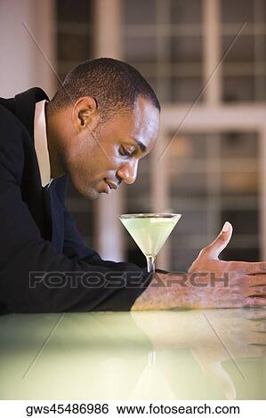 Side profile of a businessman with a martini in front of him View Large Photo Image Stock Photograph - Side profile of a businessman with a martini in front of him. Fotosearch