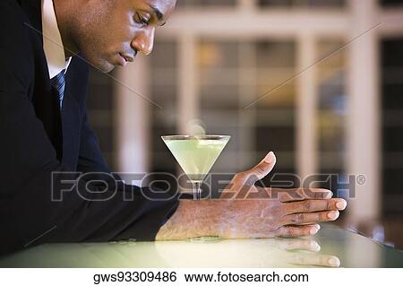 Side profile of a businessman with a glass of martini View Large Photo Image Stock Photograph - Side profile of a businessman with a glass of martini. Fotosearch