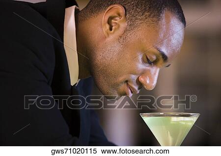 Side profile of a businessman with a glass of martini View Large Photo Image Stock Photography - Side profile of a businessman with a glass of martini. Fotosearch