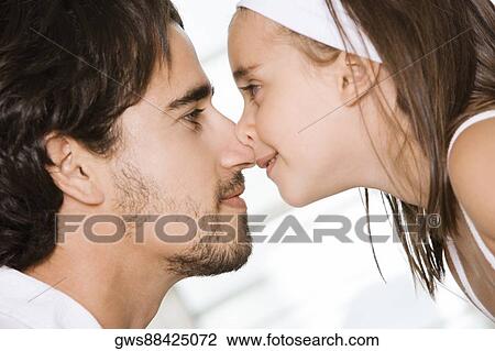 Stock Image - Side profile of a father and his daughter nuzzling. Fotosearch