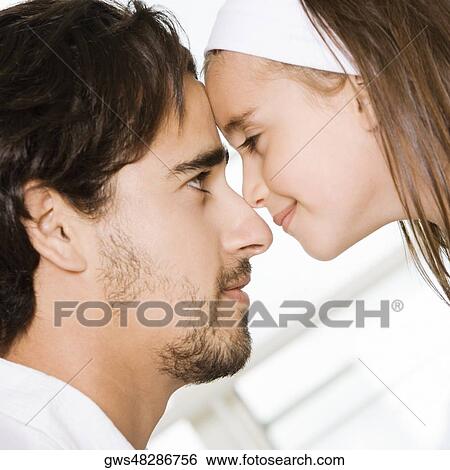 Side profile of a father looking at his daughter View Large Photo Image Stock Photograph - Side profile of a father looking at his daughter. Fotosearch
