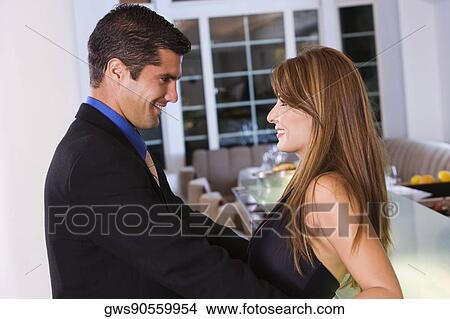 Picture - Side profile of a mid adult couple looking at each other and smiling. Fotosearch
