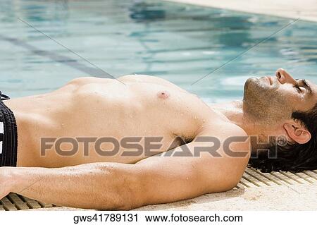 Side profile of a mid adult man lying at the edge of a swimming pool View Large Photo Image Stock Image - Side profile of a mid adult man lying at the edge of a swimming pool. Fotosearch