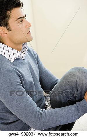 Side profile of a mid adult man sitting on the floor View Large Photo Image Stock Photo - Side profile of a mid adult man sitting on the floor. Fotosearch