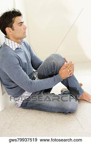 Side profile of a mid adult man sitting on the floor View Large Photo Image Stock Photo - Side profile of a mid adult man sitting on the floor. Fotosearch