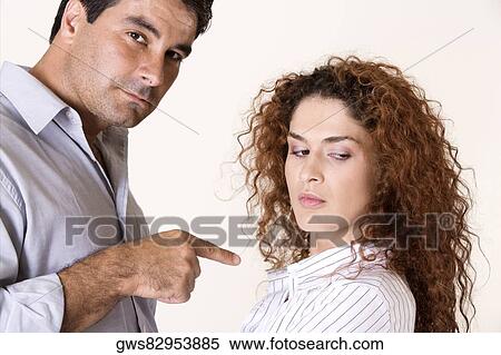 Side profile of a mid adult man pointing to a young woman View Large Photo Image Stock Photography - Side profile of a mid adult man pointing to a young woman. Fotosearch