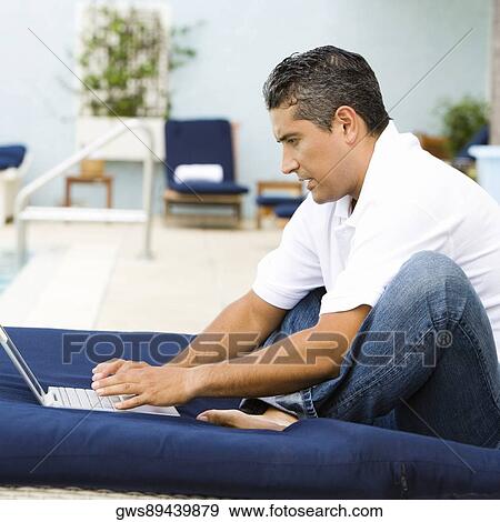 Side profile of a mid adult man using a laptop View Large Photo Image Stock Photo - Side profile of a mid adult man using a laptop. Fotosearch
