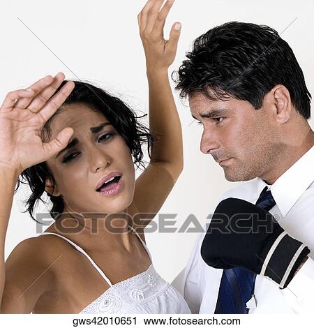 Side profile of a mid adult man wearing boxing gloves standing in front of a young woman View Large Photo Image Stock Image - Side profile of a mid adult man wearing boxing gloves standing in front of a young woman. Fotosearch