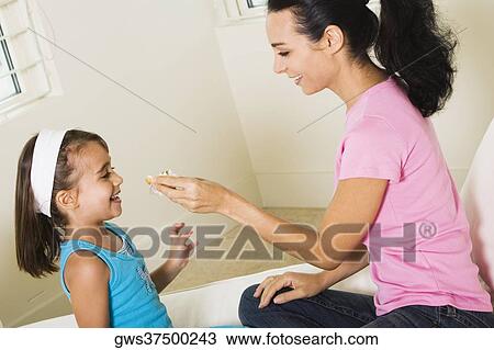 Side profile of a mother feeding her daughter View Large Photo Image Stock Image - Side profile of a mother feeding her daughter. Fotosearch
