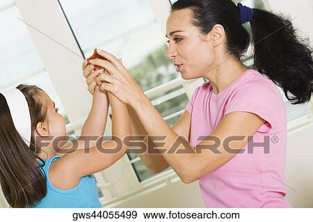 Side profile of a mother holding her daughter's hands View Large Photo Image Stock Photo - Side profile of a mother holding her daughter's hands. Fotosearch