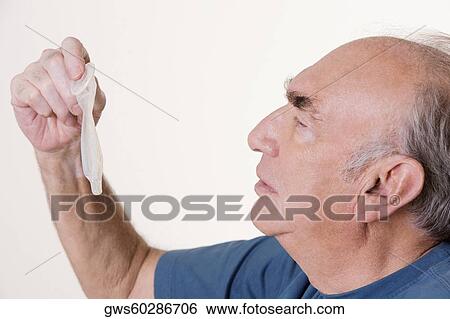 Side profile of a senior man holding a condom View Large Photo Image Stock Photograph - Side profile of a senior man holding a condom. Fotosearch