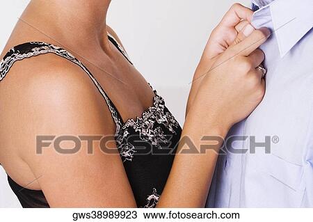 Side profile of a woman buttoning the shirt of a man View Large Photo Image Stock Image - Side profile of a woman buttoning the shirt of a man. Fotosearch