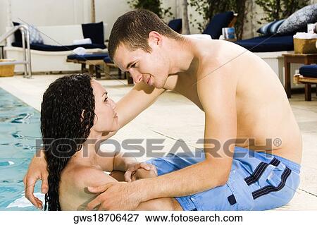 Side profile of a young couple in a swimming pool View Large Photo Image Stock Photo - Side profile of a young couple in a swimming pool. Fotosearch