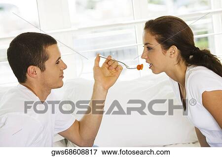Side profile of a young man feeding a young woman cherries View Large Photo Image Stock Photo - Side profile of a young man feeding a young woman cherries. Fotosearch
