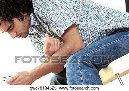 Stock Photography - Side profile of a young man holding a personal data assistant. Fotosearch
