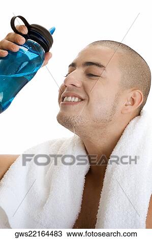 Stock Image - Side profile of a young man pouring water on his face. Fotosearch