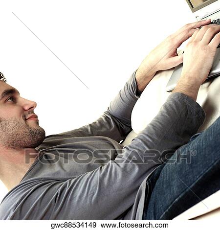 Stock Photo - Side profile of a young man using a laptop. Fotosearch