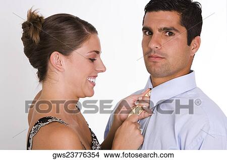 Side profile of a young woman adjusting a mid adult man's tie View Large Photo Image Picture - Side profile of a young woman adjusting a mid adult man's tie. Fotosearch