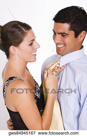 Side profile of a young woman adjusting a mid adult man's tie View Large Photo Image Stock Photo - Side profile of a young woman adjusting a mid adult man's tie. Fotosearch
