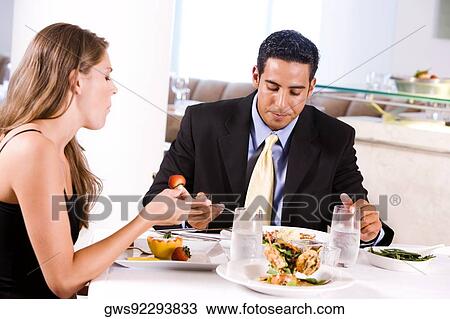 Side profile of a young woman and a mid adult man eating in a restaurant View Large Photo Image Stock Image - Side profile of a young woman and a mid adult man eating in a restaurant. Fotosearch