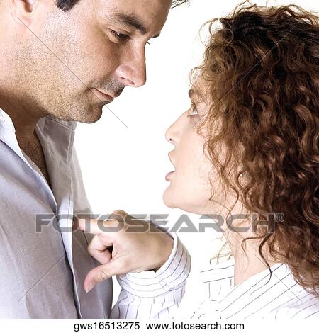 Stock Photography - Side profile of a young woman arguing with a mid adult man. Fotosearch