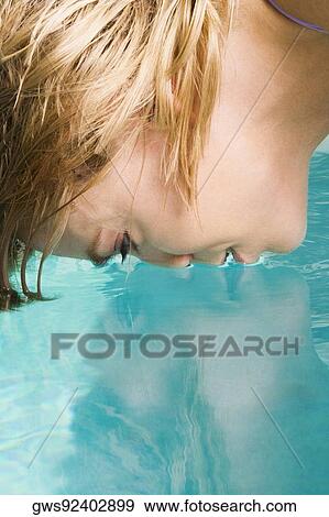 Stock Photo - Side profile of a young woman face down in a swimming pool. Fotosearch