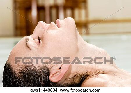 Side profile of a young woman floating on water View Large Photo Image Picture - Side profile of a young woman floating on water. Fotosearch