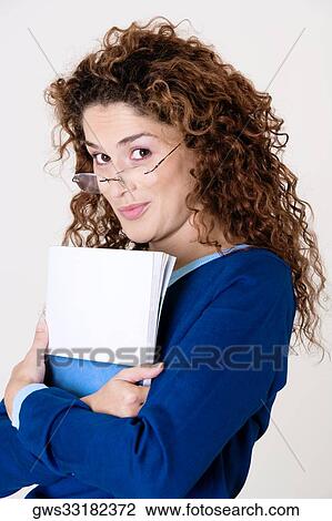 Side profile of a young woman holding a file View Large Photo Image Stock Image - Side profile of a young woman holding a file. Fotosearch