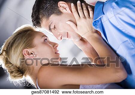 Side profile of a young woman holding the face of a mid adult man View Large Photo Image Stock Image - Side profile of a young woman holding the face of a mid adult man. Fotosearch