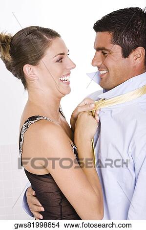 Side profile of a young woman pulling a mid adult man's tie View Large Photo Image Picture - Side profile of a young woman pulling a mid adult man's tie. Fotosearch
