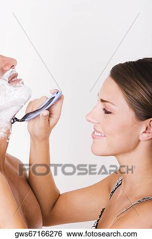 Side profile of a young woman shaving a mid adult man View Large Photo Image Stock Photograph - Side profile of a young woman shaving a mid adult man. Fotosearch