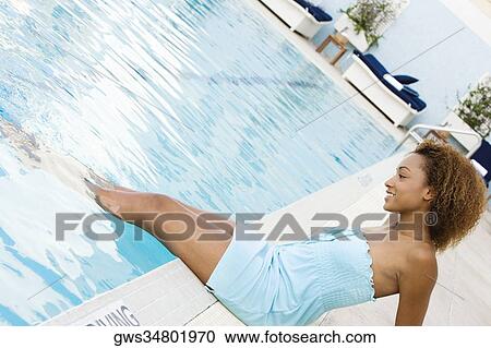 Side profile of a young woman sitting at the poolside View Large Photo Image Stock Image - Side profile of a young woman sitting at the poolside. Fotosearch