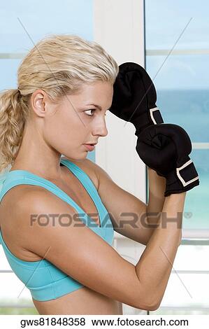 Side profile of a young woman wearing boxing gloves View Large Photo Image Stock Photo - Side profile of a young woman wearing boxing gloves. Fotosearch
