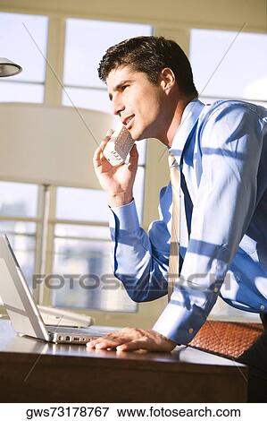 Side profile of businessman talking on a cordless phone View Large Photo Image Stock Photo - Side profile of businessman talking on a cordless phone. Fotosearch