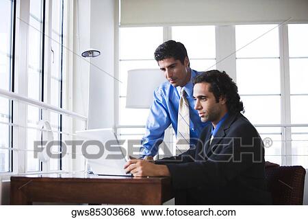 Stock Photo - Two businessmen in front of a laptop. Fotosearch