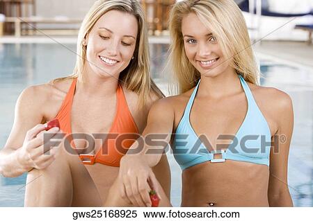 Two young women sitting at the poolside View Large Photo Image Stock Photography - Two young women sitting at the poolside. Fotosearch